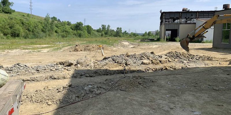 A professional excavator clearing and flattening land, mostly made of dirt